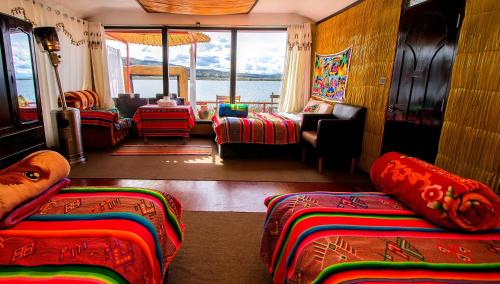 a room with several beds and a living room at Uros Samaraña Uta Lodge in Puno