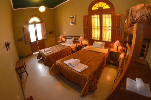 a bedroom with two beds and two windows at El Caminante Class in Arequipa