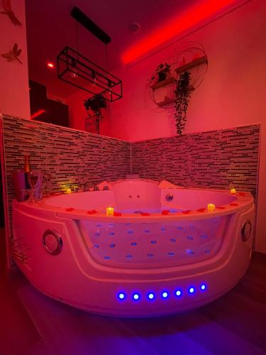 a pink bath tub with lights in a room at Bulle d'Amour in Pontault-Combault