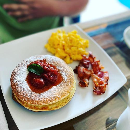 a plate of food with pancakes and scrambled eggs at Hotel Santos De Piedra - MARANATHA BARICHARA in Barichara