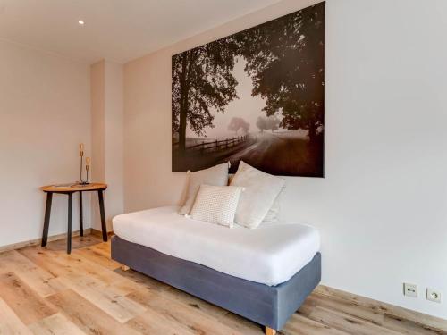 a bedroom with a bed with a painting on the wall at Heers Retreat with Sauna in Heers