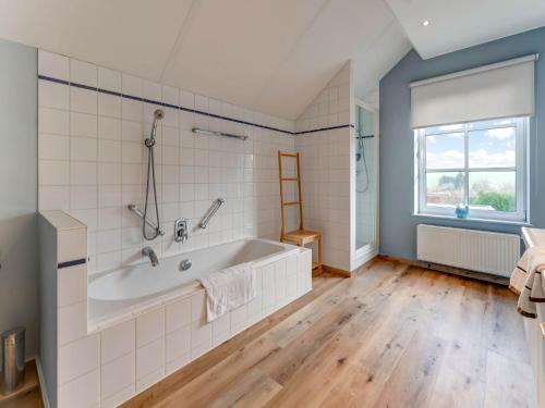 a bathroom with a bath tub and a window at Pleasant Holiday Home in Heers with Outdoor Sauna in Heers