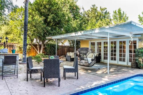 a patio with chairs and a swing next to a pool at Villa Sausalito - Newly Designed 4BR HOUSE & POOL by Topanga in Los Angeles