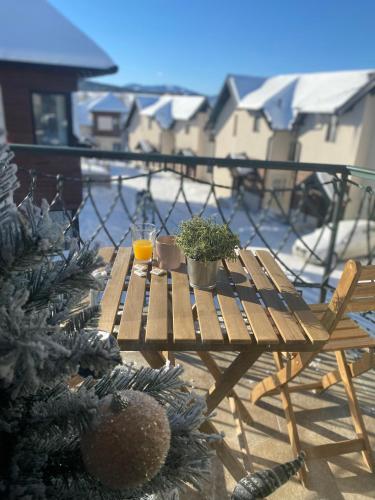 a wooden table with potted plants on a balcony at Sunny Sight Zlatibor in Zlatibor
