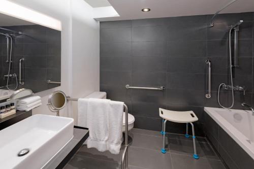 a bathroom with a sink and a toilet and a shower at Hotel PUR, Quebec, a Tribute Portfolio Hotel in Quebec City