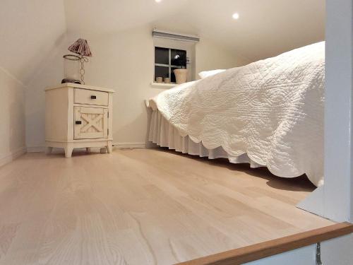 1 dormitorio con 1 cama y suelo de madera en 4 person holiday home in TORSH LLA en Torshälla