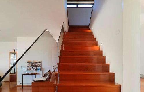 una escalera en una casa con suelo de madera y paredes blancas en Hill & Beach house, en Viana do Castelo