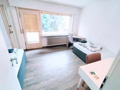 uma sala de estar com duas camas e uma janela em FMI Apartment LST Next to Airport em Rüsselsheim