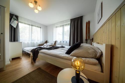 a bedroom with a bed and a table with a lamp at CZARNY JELEŃ in Szklarska Poręba