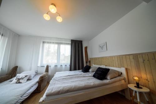 a bedroom with two beds and a window at CZARNY JELEŃ in Szklarska Poręba