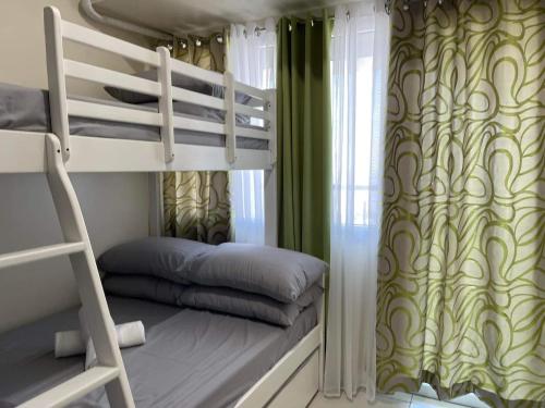 a dorm room with bunk beds and a ladder at Taft Ave Green Residences 1BR by darpm in Manila