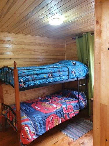 a bedroom with two bunk beds in a cabin at Cabañas Los Castaños Chovellén in Chovellén