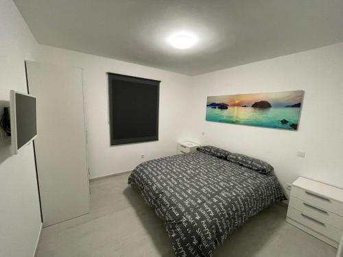 a bedroom with a bed and a flat screen tv at Teresita Deluxe with pool in Caleta De Fuste