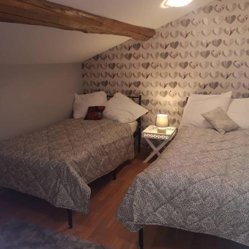 une chambre avec deux lits et une table avec une lampe dans l'établissement Le Pommier Chambre d'hote, à Clussais-la-Pommeraie