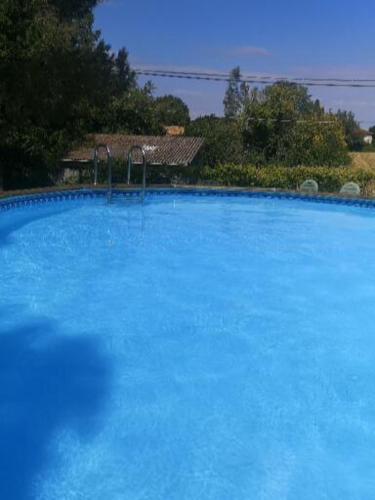 une grande piscine bleue dans une cour dans l'établissement Le Pommier Chambre d'hote, à Clussais-la-Pommeraie