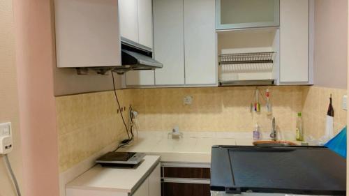 a kitchen with white cabinets and a counter top at KTC TRADE CENTRE in Kota Bharu