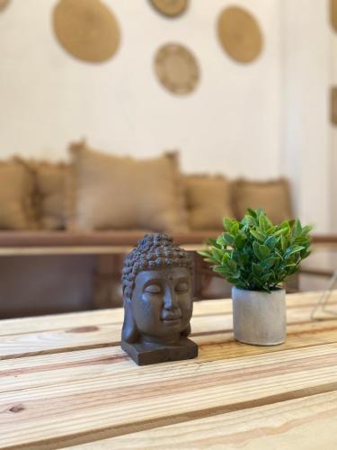 a statue of a head on a table with a plant at Kumbianna in Cartagena de Indias