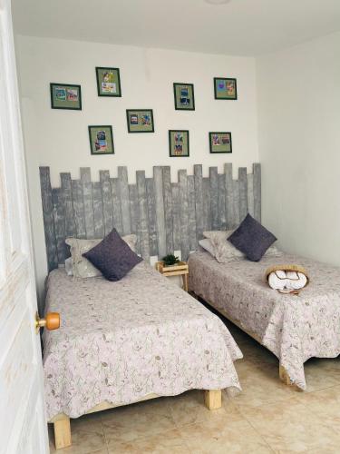 a bedroom with two beds and pictures on the wall at Kumbianna in Cartagena de Indias