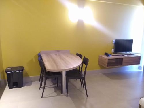 einen Tisch und Stühle in einem Zimmer mit TV in der Unterkunft Grein Solar das Águas Park Resort in Olímpia