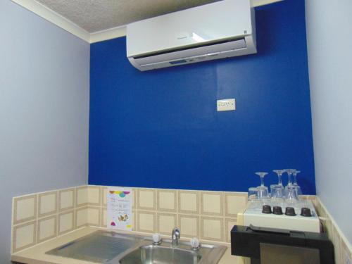 baño con lavabo y pared azul en Rockhampton Court Motor Inn, en Rockhampton