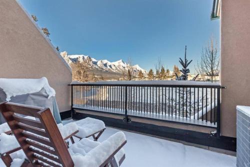 two chairs on a balcony with a view of the mountains at Incredible Mountain View Townhouse in DT Canmore w/ A/C & U/A Parking in Canmore