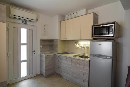 uma cozinha com um frigorífico e um micro-ondas em Apartments Sarc Rovinj em Rovinj