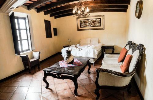 a bedroom with a bed and a table and chairs at Casa Catalina in Antigua Guatemala