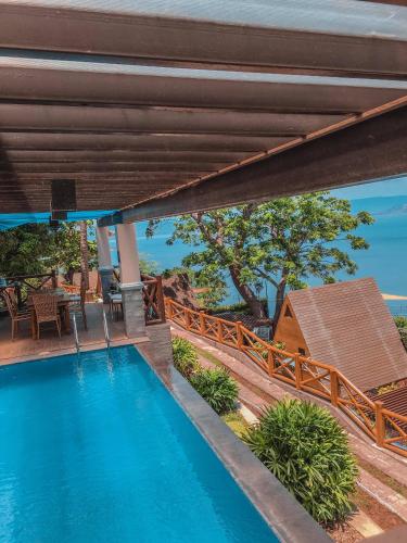 an outdoor swimming pool with a view of a house at Noni's Resort in Alitagtag