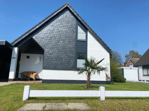 a white house with a palm tree in front of it at Traumhaftes geräumiges Ferienhaus in Meernähe in Bruinisse