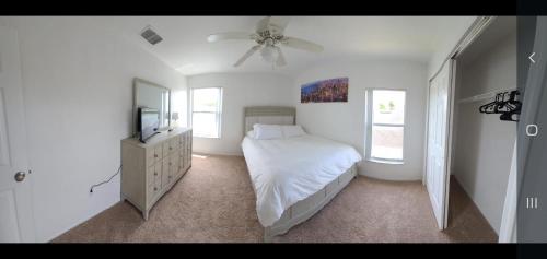 um quarto branco com uma cama e uma ventoinha de tecto em Electric Heated Private Pool 4 Bedroom 3 Bath 2 Story Single Family Home!!!! em Kissimmee