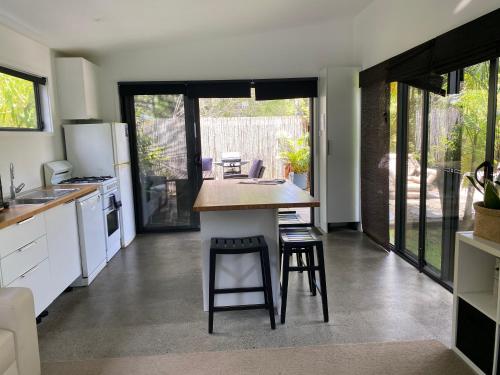 a kitchen with white appliances and a counter with stools at Bali In Berrara in Berrara