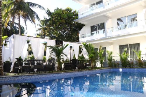 a hotel with a swimming pool in front of a building at La Vera Boutique Hotel, Mandrem in Mandrem