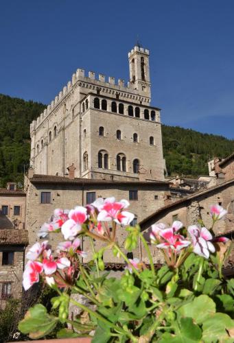 an old building with pink flowers in front of it at Locanda Del Duca in Gubbio