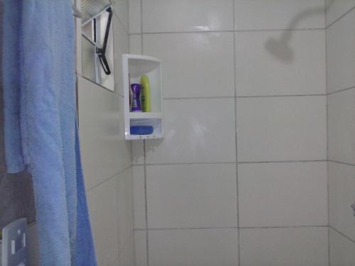 a white tiled bathroom with a soap holder on the wall at Pousada da Didi in Belém