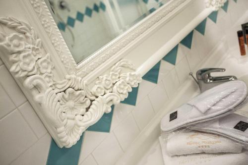 W łazience znajduje się lustro i umywalka. w obiekcie Hotel Posillipo w mieście Gabicce Mare