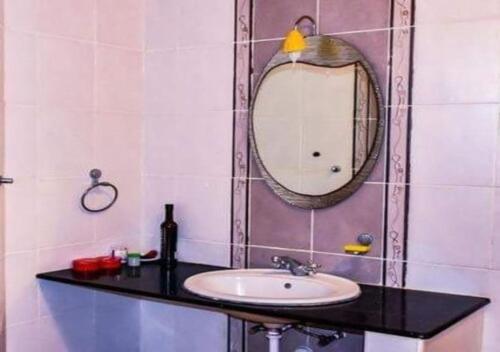 a bathroom with a sink and a mirror at Watamu Adventist Beach Resort in Watamu