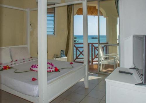 a bedroom with a bed with a view of the ocean at Watamu Adventist Beach Resort in Watamu