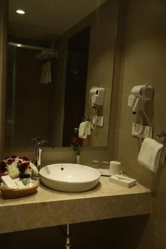 a bathroom with a white sink and a mirror at YN Hotels in Bengaluru