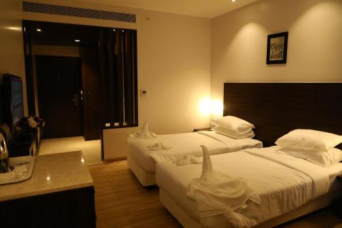 a hotel room with two beds with towels on them at YN Hotels in Bengaluru