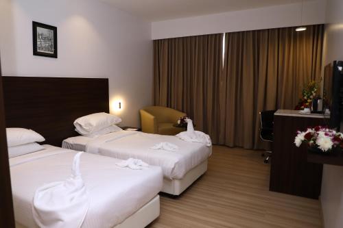 a hotel room with two beds with white sheets at YN Hotels in Bengaluru