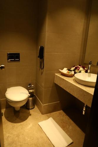 a bathroom with a toilet and a sink at YN Hotels in Bengaluru