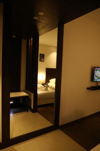 a mirror in a room with a bed and a bedroom at YN Hotels in Bengaluru