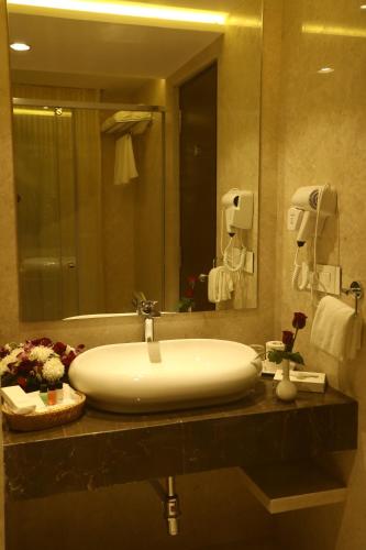 a bathroom with a sink and a large mirror at YN Hotels in Bengaluru