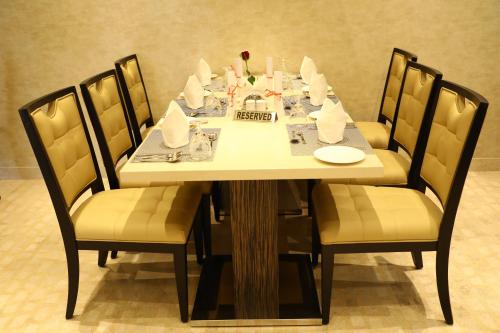 a dining room table with chairs and a table set with food at YN Hotels in Bengaluru