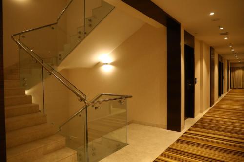 a staircase with glass railing in a building at YN Hotels in Bengaluru