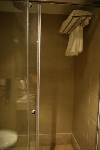 a shower with a glass door and a sink at YN Hotels in Bengaluru