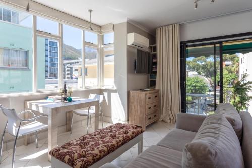 a living room with a couch and a table at Cosy and Classy Sea Point Apartment in Cape Town