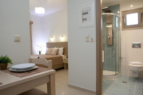 a bathroom with a shower and a toilet and a bedroom at Savinos Rooms in Vasiliki