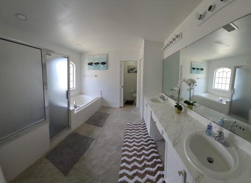 uma casa de banho branca com 2 lavatórios e um chuveiro em Electric Heated Private Pool 4 Bedroom 3 Bath 2 Story Single Family Home!!!! em Kissimmee