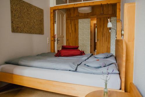 a bed with a wooden frame in a room at Hof Osterholz in Loit